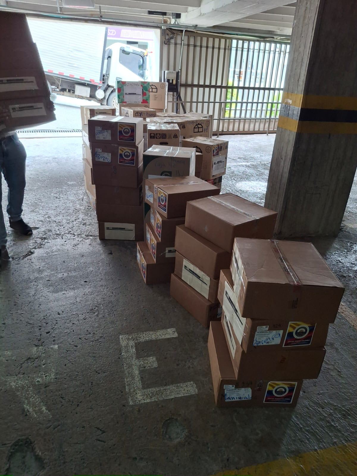 Donaciones apiladas junto a un camión en el punto de acopio de S.C.A.R.E.