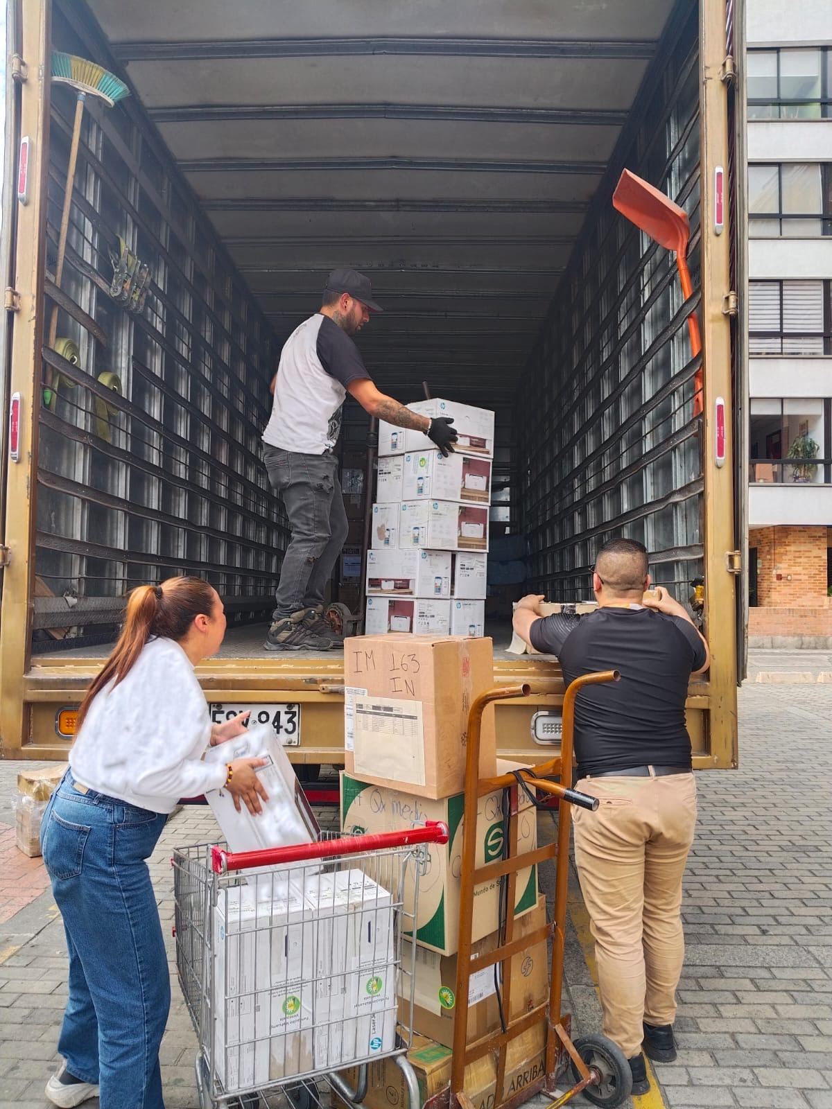 Voluntarios apilando cajas de donaciones dentro de un camión.
